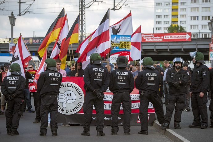 Gli attivisti del partito di estrema destra NPD sono visti dietro una linea di polizia all'inizio delle loro marce sul ponte Jannowitz a Berlino il 26 aprile 2014. (AFP Photo / Odd Andersen)