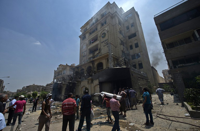 Egyptians gather outside the burnt
  headquarters of the Muslim Brotherhood in the Moqattam district
  of Cairo on July 1, 2013 after it was set ablaze by opposition
  demonstrators overnight. (AFP Photo / Khaled Desouki)