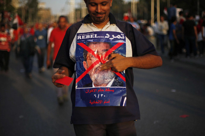 A protester opposing
  Egyptian President Mohamed Morsi holds an anti-Morsi poster
  during a protest in front of the presidential palace in Cairo
  June 30, 2013. (Reuters)