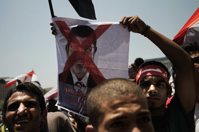 An Egyptian
  opposition supporter holds a crossed-out picture of President
  Mohammed Morsi as hundreds gather for a demonstration against
  Morsi and the Muslim Brotherhood in Cairo's landmark Tahrir
  Square on June 29, 2013. (AFP Photo)