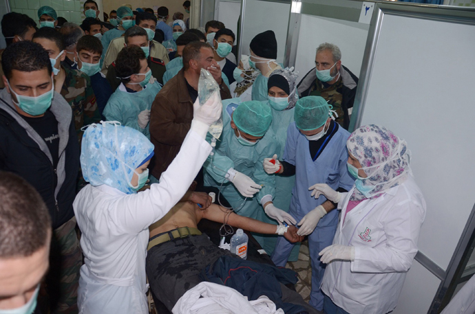Medics and other masked people attend to a man at a hospital in Khan al-Assal in the northern Aleppo province, as Syria's government accused rebel forces of using chemical weapons for the first time on March 19, 2013 (AFP Photo / HO-SANA)