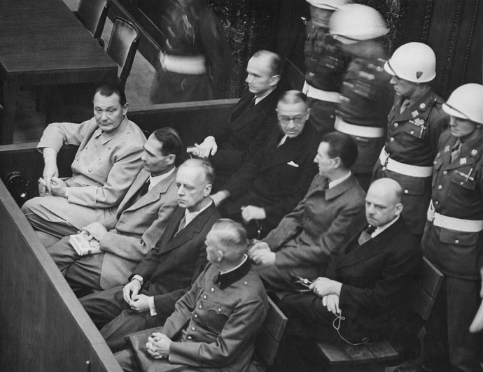 Nuremberg Trials. Defendants in their dock, circa 1945-1946. (in front row, from left to right): Hermann Göring, Rudolf Heß, Joachim von Ribbentrop, Wilhelm Keitel (in second row, from left to right): Karl Dönitz, Erich Raeder, Baldur von Schirach, Fritz Sauckel (Image from Wikipedia)